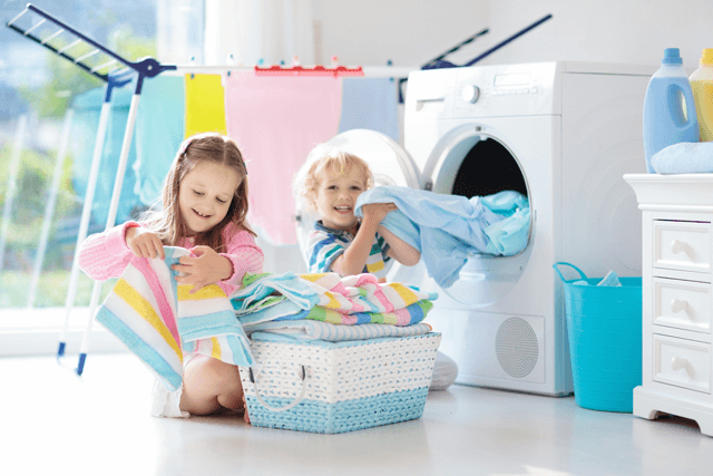 Kids holen die frische Wäsche aus der Waschmaschine